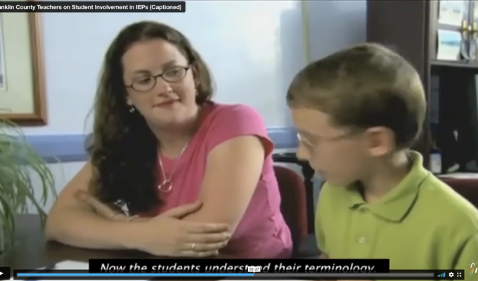 Screen grab from video featuring a teacher sitting with a young student discussion his IEP.