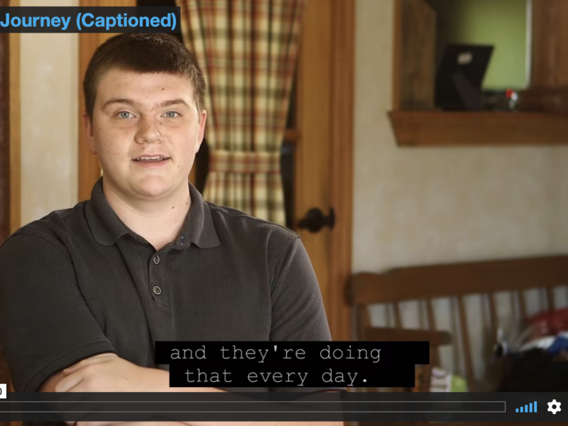 Video capture - Cayden sits in his house while being interviewed about his journey.