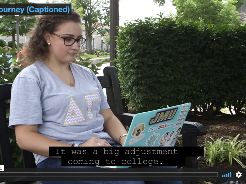 Video capture: Annie sits outside on a bench, her laptop open.