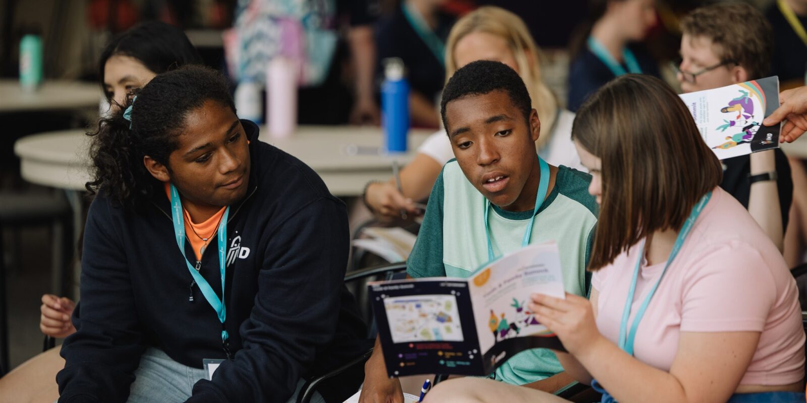 young adults look at a booklet together