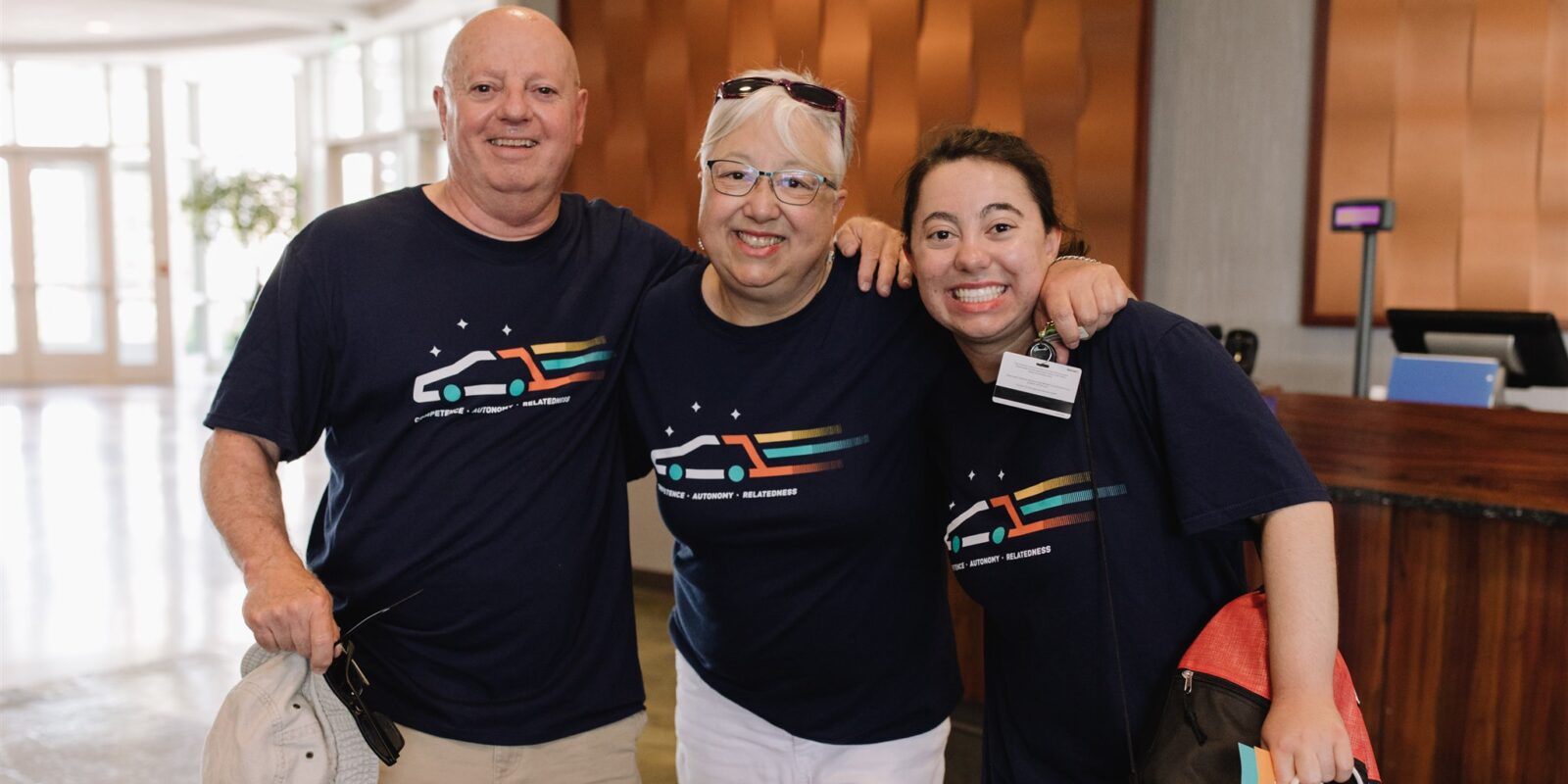 Dad, mom, and daughter with arms around each other, each wearing a navy blue I'm Determined shirt.