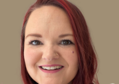 Headshot of Meghan Hyatt, female with red highlighted hair, wearing a white shirt.