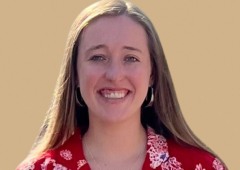 Headshot of Hunter, smiling and wearing a red flowery dress.