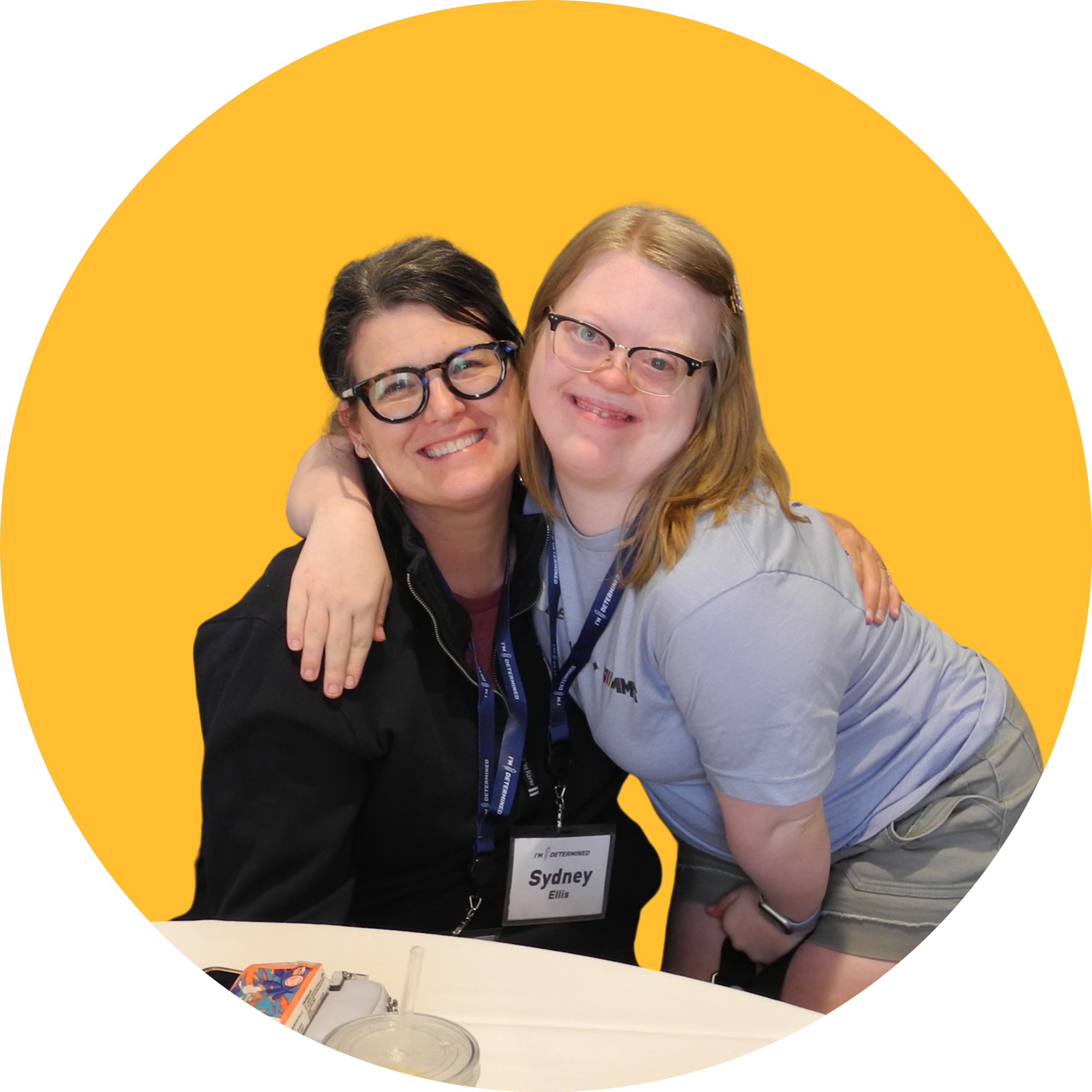 Youth leader Sydney crouching down to put her arm around her mom, both smiling, with a bold yellow background.