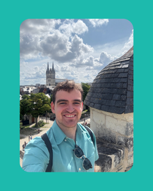 Image of Reeve taking a selfie in front of a tall building.